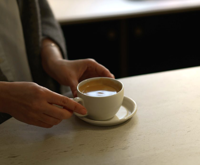 Une tasse de café posée sur un plan de travail en pierre