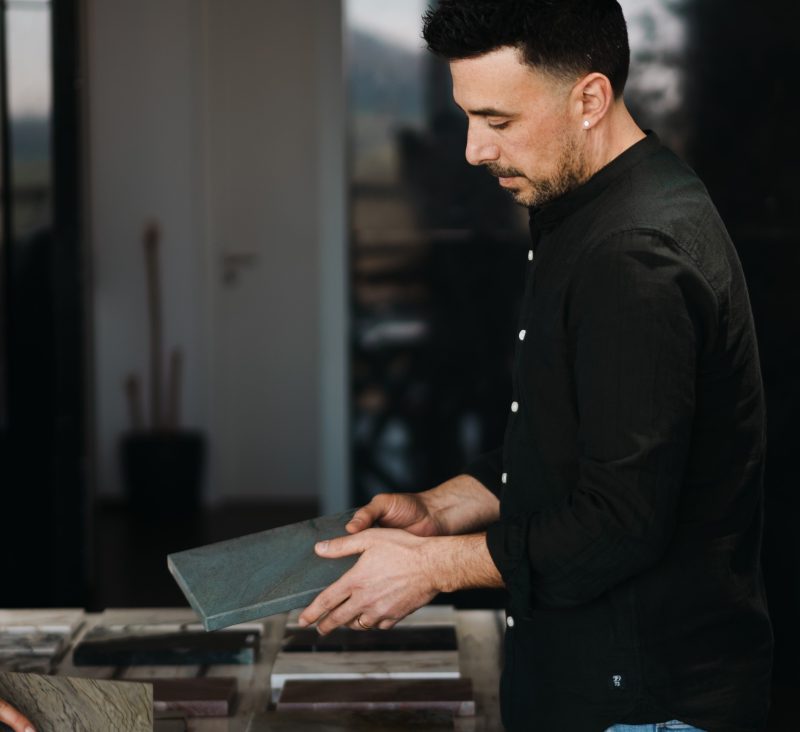 Romain examine une tranche de pierre à l'atelier